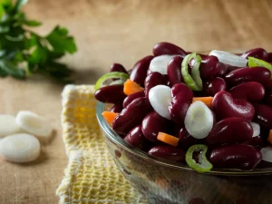 Bohnensalat mit dunkelroten Bohnen, Zwiebelringen und Paprika in einer Glasschüssel